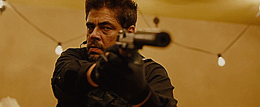 Sicario. Plot summary and story structure. Benicio Del Toro scowls and fires a silenced pistol.